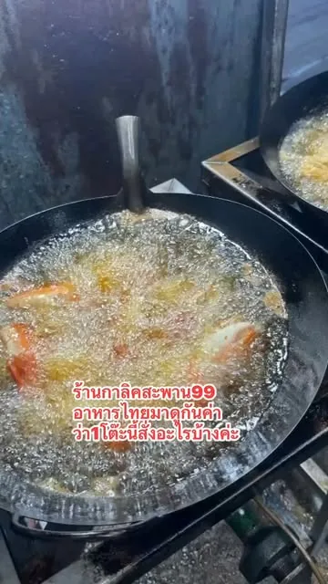 Prawns frying in a deep wok of hot oil.