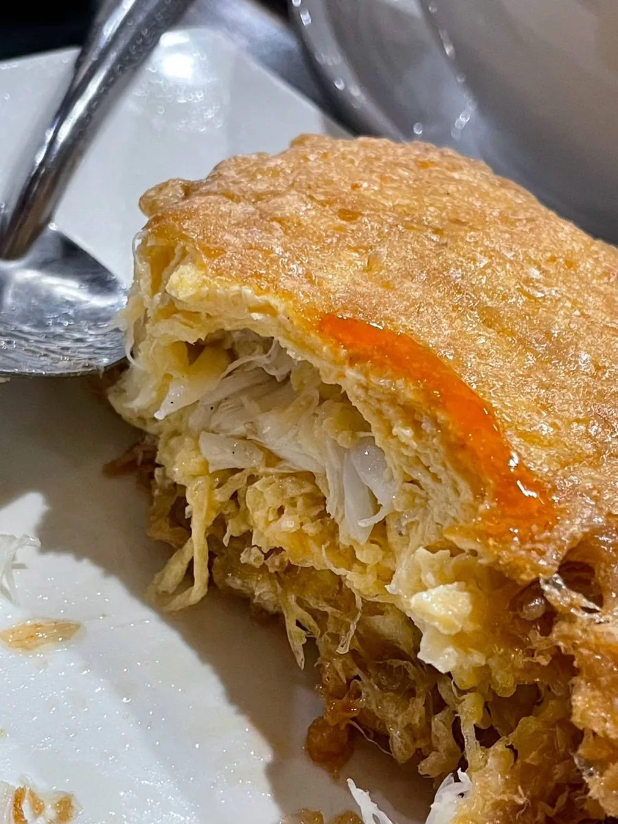 A cross-section of the omelette: layers of crab and soft egg under a crisp shell.